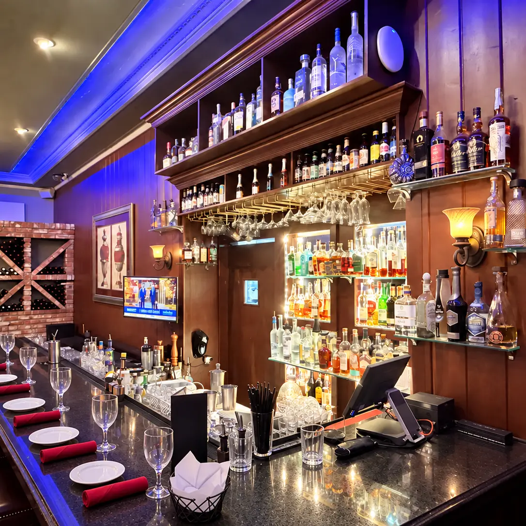 The bar at Baci Bistro & Bar, its back shelves lit and the counter set